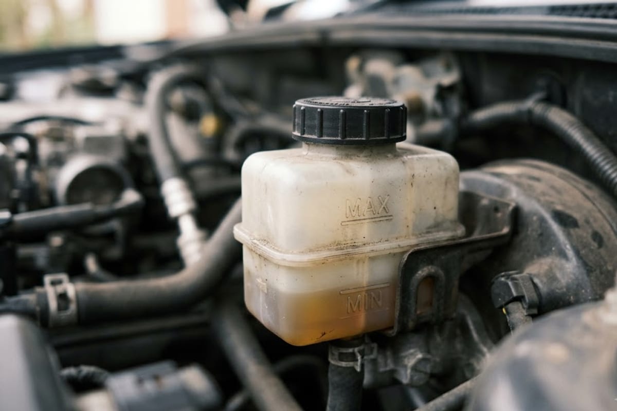 A hydraulic fluid reservoir with the level below the minimum mark